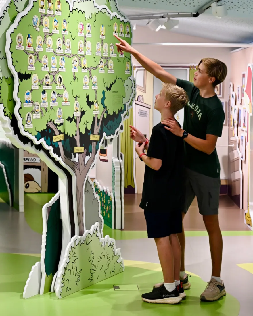 Flo und Ben vor dem Stammbaum der Ducks im Erika Fuchs Haus